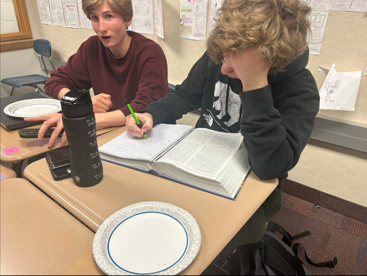 Junior Noah Khan (right), attempts to finish his homework before the game night. “I am trying so hard to get everything done as fast as possible, so I can just hang out with my friends and game with them later,” he said. 