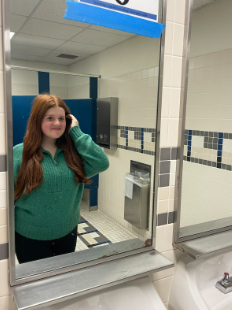 Sophomore Hannah Sevening, looks at herself through the mirror in the bathroom on Nov. 17. Sevening says that she feels that her red hair is a big part of her personality and who she really is however, it shouldn’t be the only thing that people think of her. 