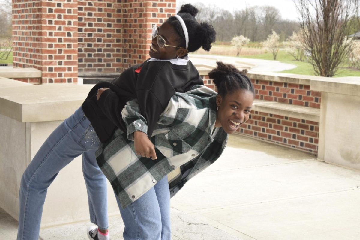 Sophomore Daphne Uche-Ejekwu (right) tries to pick up her sister, Abbie Uche-Ejekwu (left) on April 4th.  “I would miss going to school with (Daphne) when I go to college next year,” said Abbie. 
