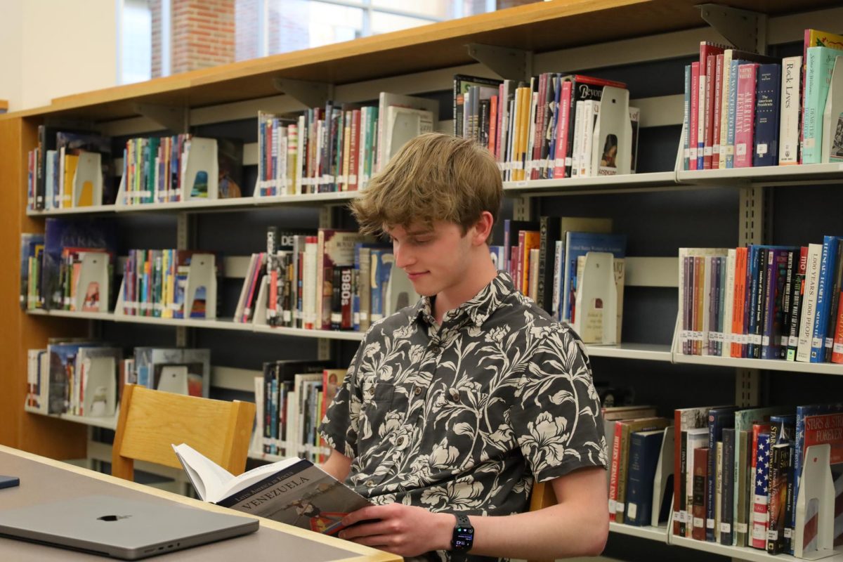 Nick Stitle, a teen author and senior, reads a book about Venezuela. Stitle said the writing fair was a great way to introduce writing to teenagers who may be interested in writing or authoring books. 