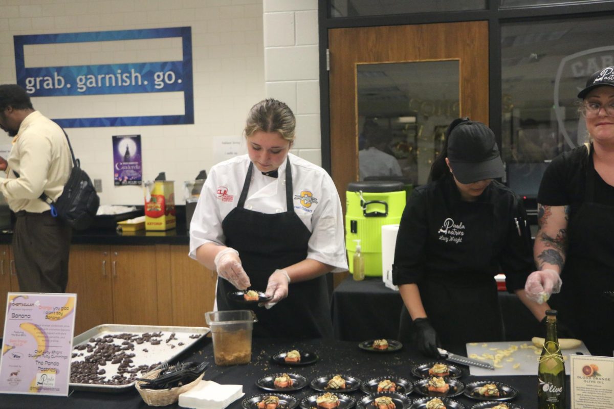 Sophomore Ruby Cummings (left) and Panda Pasteries chef Lucy Wright (right) create a blood orange cardamom olive oil cake. The cake was topped with dark chocolate ganache and walnut praline.