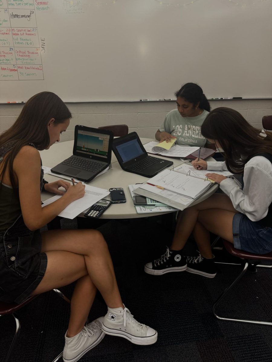 Seniors Abby Imler, Emma Imler, and Asritha Chittemreddy tutor for NHS in room E137. Chittemreddy said NHS has helped her engage in more community service throughout the year.