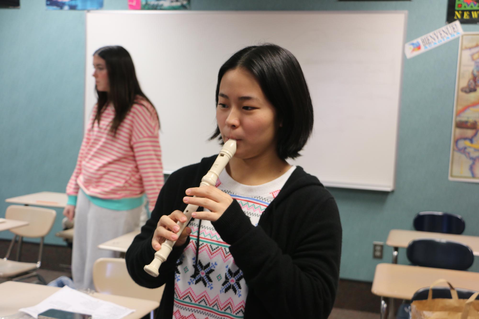 Junior Emmanuella Choi practices the Christmas carol “Rudolph the Red-Nosed Reindeer” on a recorder for French III before the class performs for the other language rooms on Dec.12. French students caroled to three classrooms, one of the songs being “Entre le bœuf et l'âne gris” which directly translates to between the ox and the grey donkey based off of the presence of the two animals at the birth of Jesus additionally, they sang “Rudolph the Red-Nosed Reindeer” a Christmas classic. 