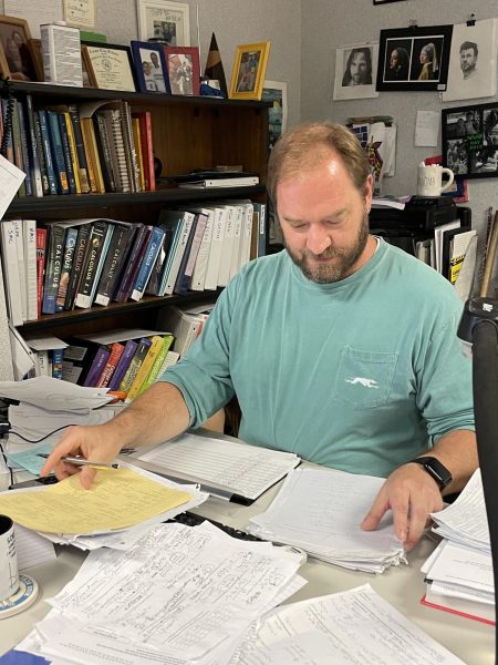 Math Club sponsor Peter Beck works at his desk grading test papers. Beck said that overall, Math Club would not see any particularly big changes despite new leadership and sponsorship. 