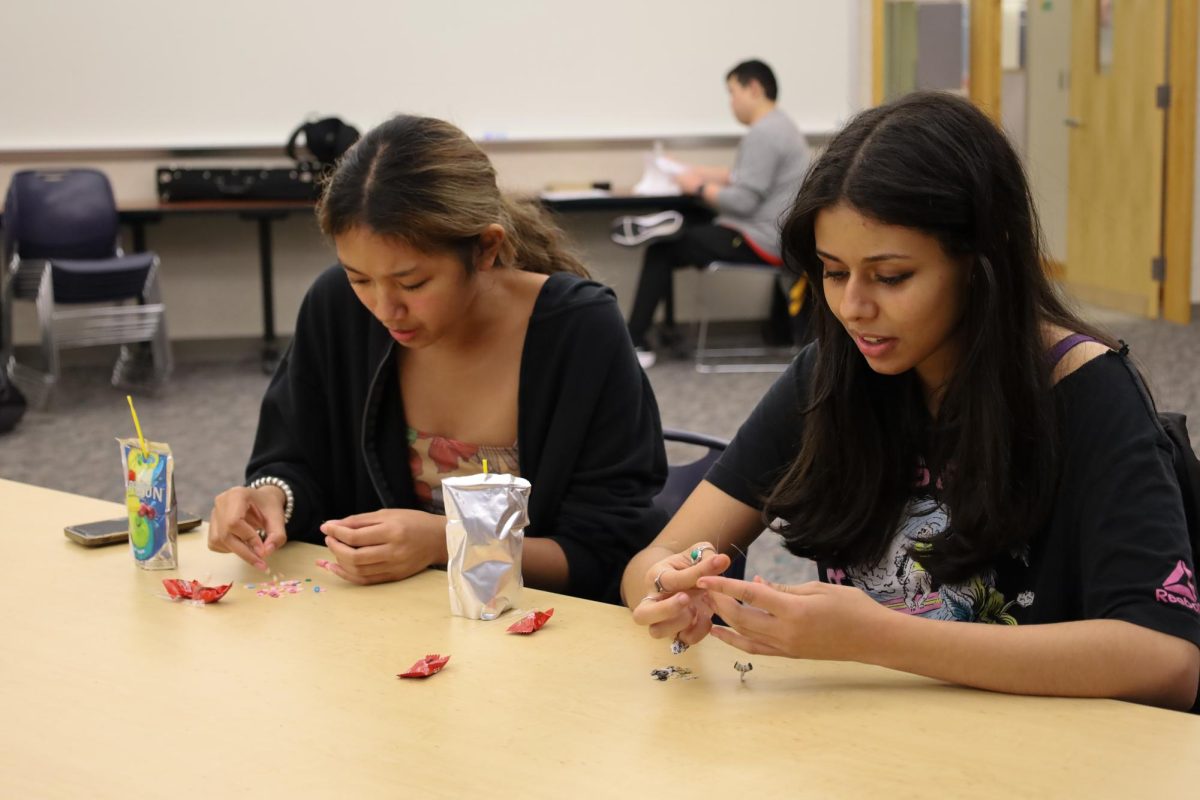 Juniors Marielle Pabia and Joury Elkadiri make bracelets at the A5 Mid-Autumn Festival meeting on Sept. 27. The meeting had crafts and mooncakes. 