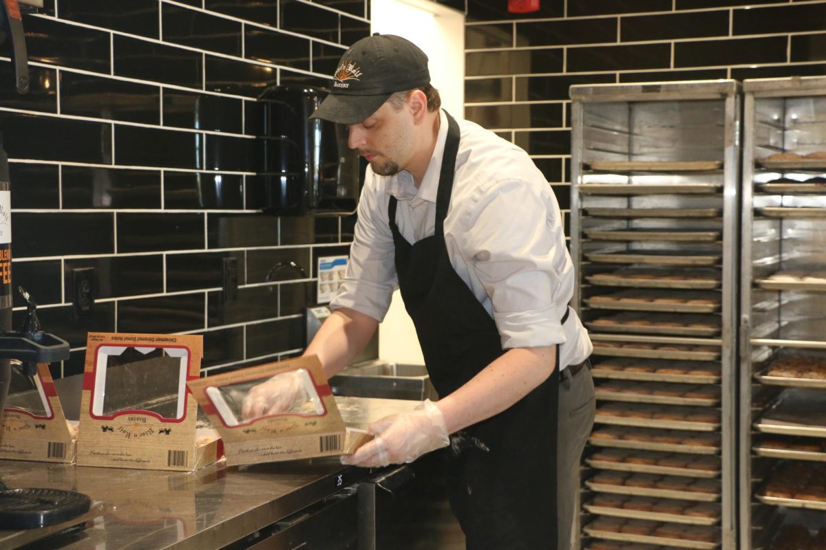 Michael Swank, general manager of Rise‘n Roll, organizes cinnamon caramel donuts on Oct. 19. "All of our products are made from the Amish. They're baked up in Middlebury, Indiana, so there's a small Amish community up there," Swank said.