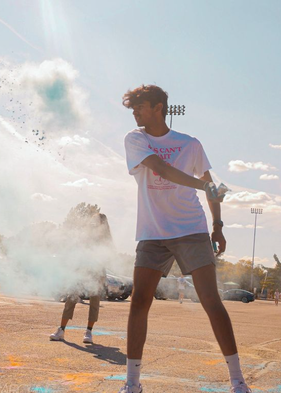 Ishan Choudhary, Cabinet member and senior, throws colored powder at participants in the race for Riley on Sept. 14.