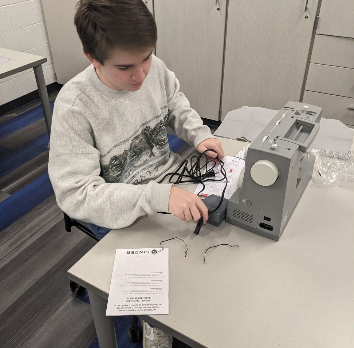 Senior Jack Kennedy assembles a new sewing machine to use for costume preparations. The sewing machine was purchased with a grant by the Carmel Education Foundation during the 2023-2024 school year.