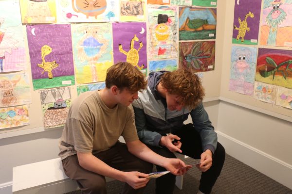 Juniors Nate Ventura and Tysen Pauwels look over postcards on Nov. 16, 2024 at the Carmel Arts Council Children's Art Gallery. They viewed all of the artwork done by children from around the city and learned about the history of the art gallery. “It was cool to see all of the things created by little kids and find out more about Carmel,” Ventura said.