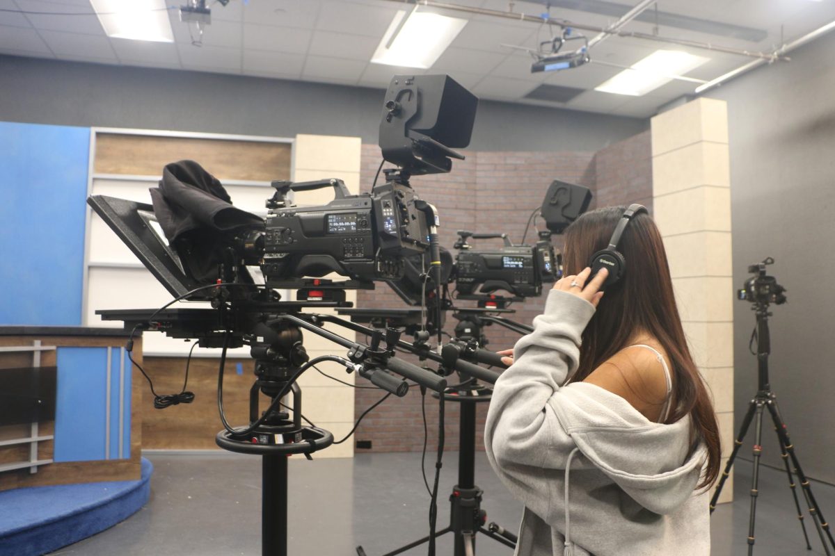 Senior Jessica Dinh films in the CHTV studio. Dinh said her favorite part of the filmmaking process is editing.    