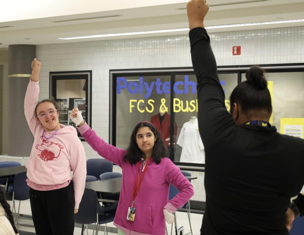 A Unified Cheer team coach guides members of the team through their chants in the Main Cafeteria on Nov. 19, 2024. They have been practicing and meeting a couple times a week after school. 