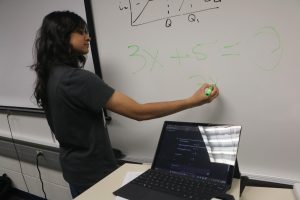 Senior Feryal Haider uses ChatGPT to solve math problems on a whiteboard on Dec. 3. Haider said effective AI use has helped her perform better in school. 