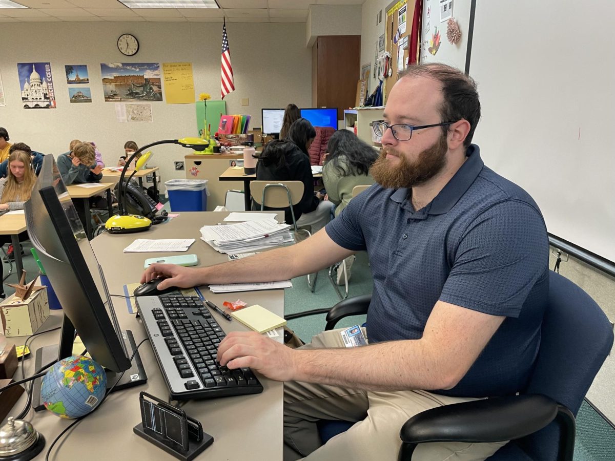  Club sponsor Matthew Cinkoske works at his desk. Cinkoske said the Quiz Bowl members have grown in their strengths. “Everyone works hard, they’re in high-level classes, and they want to do their best,” Cinkoske said.