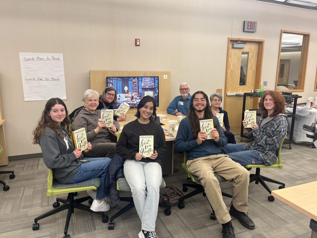 Silverhounds members pose with West with Giraffes, written by Lynda Rutledge, in the media center on Feb. 21. Members will discuss their thoughts on the book at the next Silverhounds meeting.