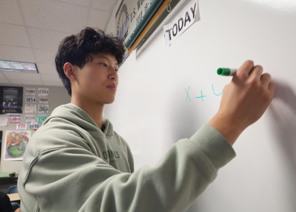 Junior Grant Mu practices a math problem on a whiteboard for the SAT during SSRT on Sept. 4. “This was my first time taking the SAT, and it was a lot tougher than I thought it would be. The way the online SAT is set up just puts more pressure on me,” Mu said.