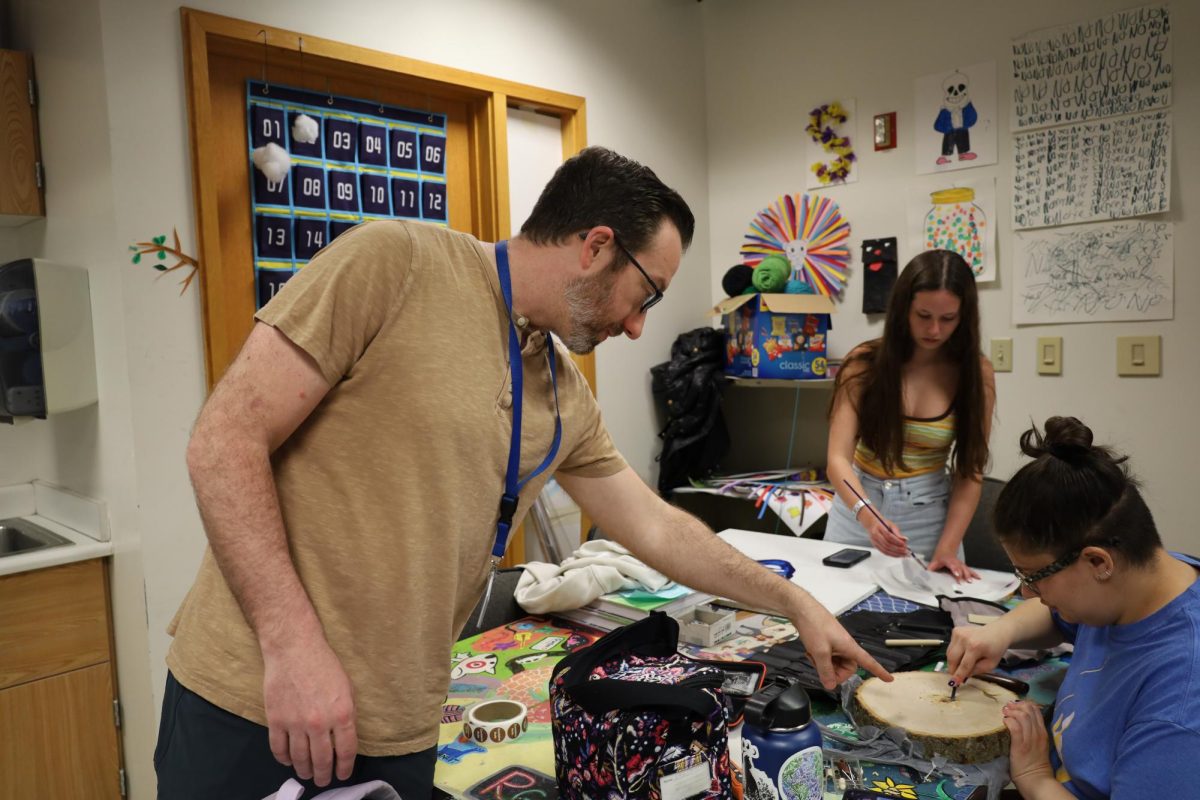 Andrew Murray, AP 2D Art teacher, advises a student on their project during his SSRT period. He said, “It stinks. All of our classes are smaller, we don't have as many art classes anymore because students don't have to take it.”
