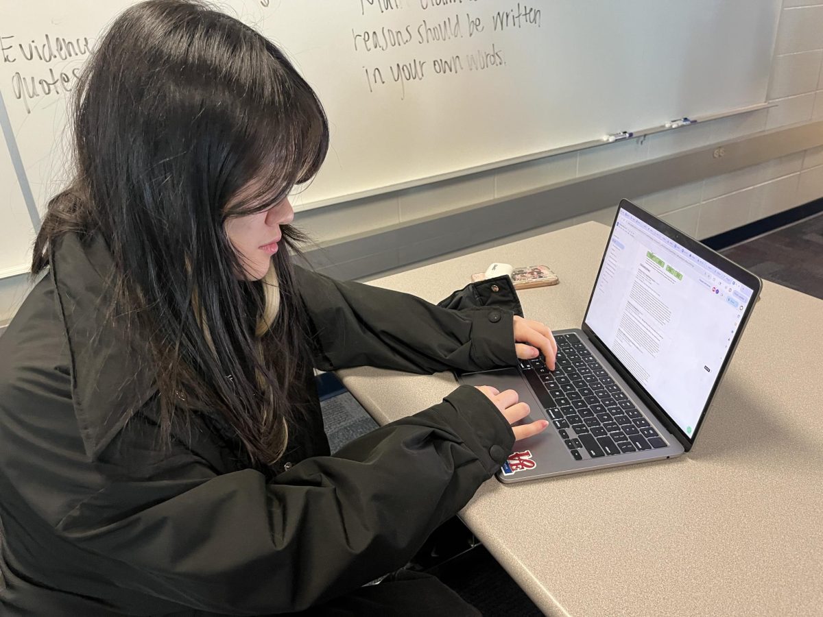 Junior Chelsea Meng looks at the program of studies during SSRT on Jan. 20. Meng said, “Junior year is almost over and it’s so surreal.” 