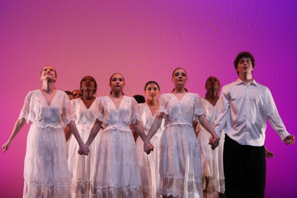 A group of performers hold hands as they dance the routine to their last song “Walk With Me” during “The Space Between” recital on March 12. Held in the Dale E. Graham auditorium, the spring dance recital premiered at 7 p.m.