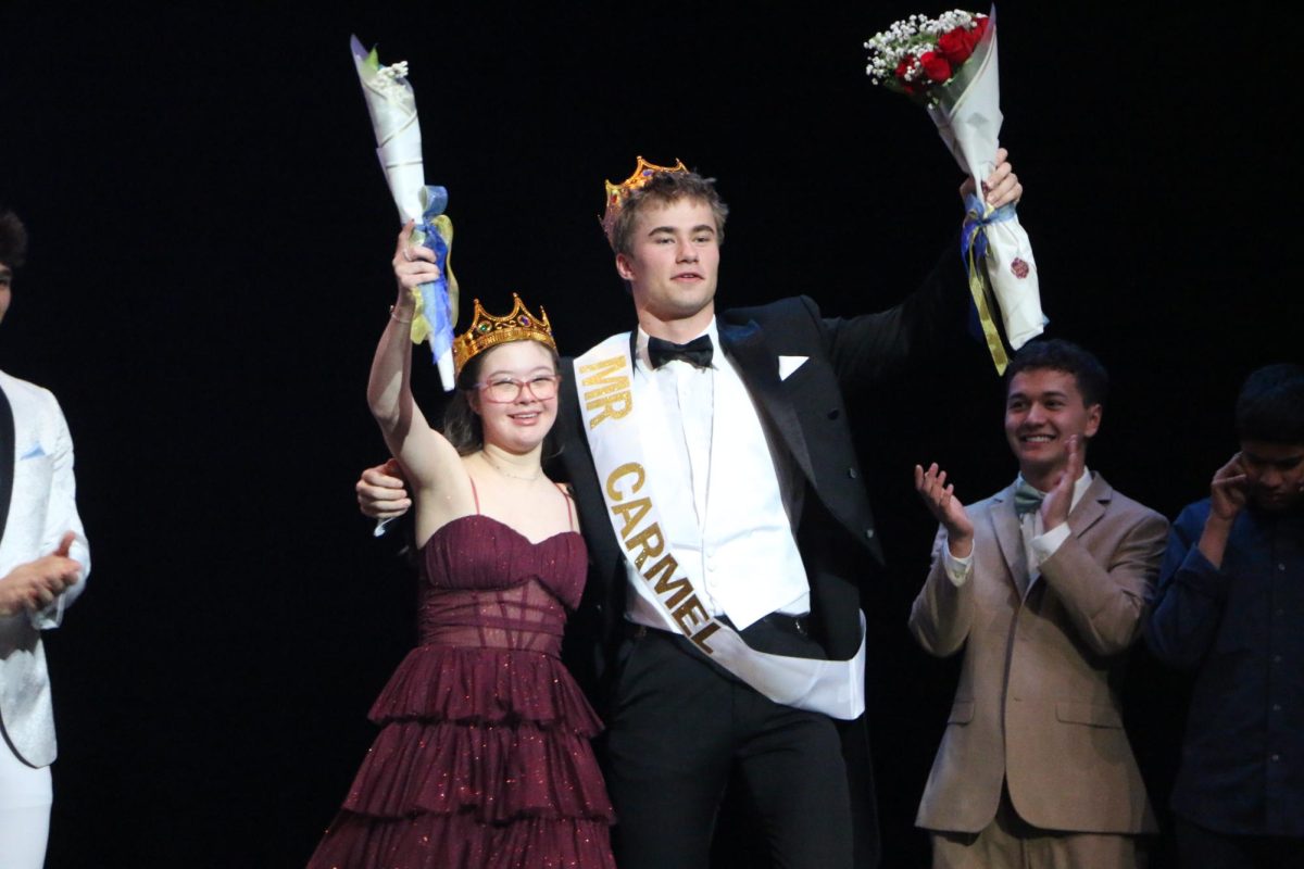 Sophomore Catalina Joyce (left) and senior Spencer Sell (right) celebrate their win during the Mr. Carmel event in the Dale E. Graham auditorium on March 20. Sell and his escort, Joyce, took home the crown. Hosted by the CHS Champions Together organization, the event raised donations for the Special Olympics.