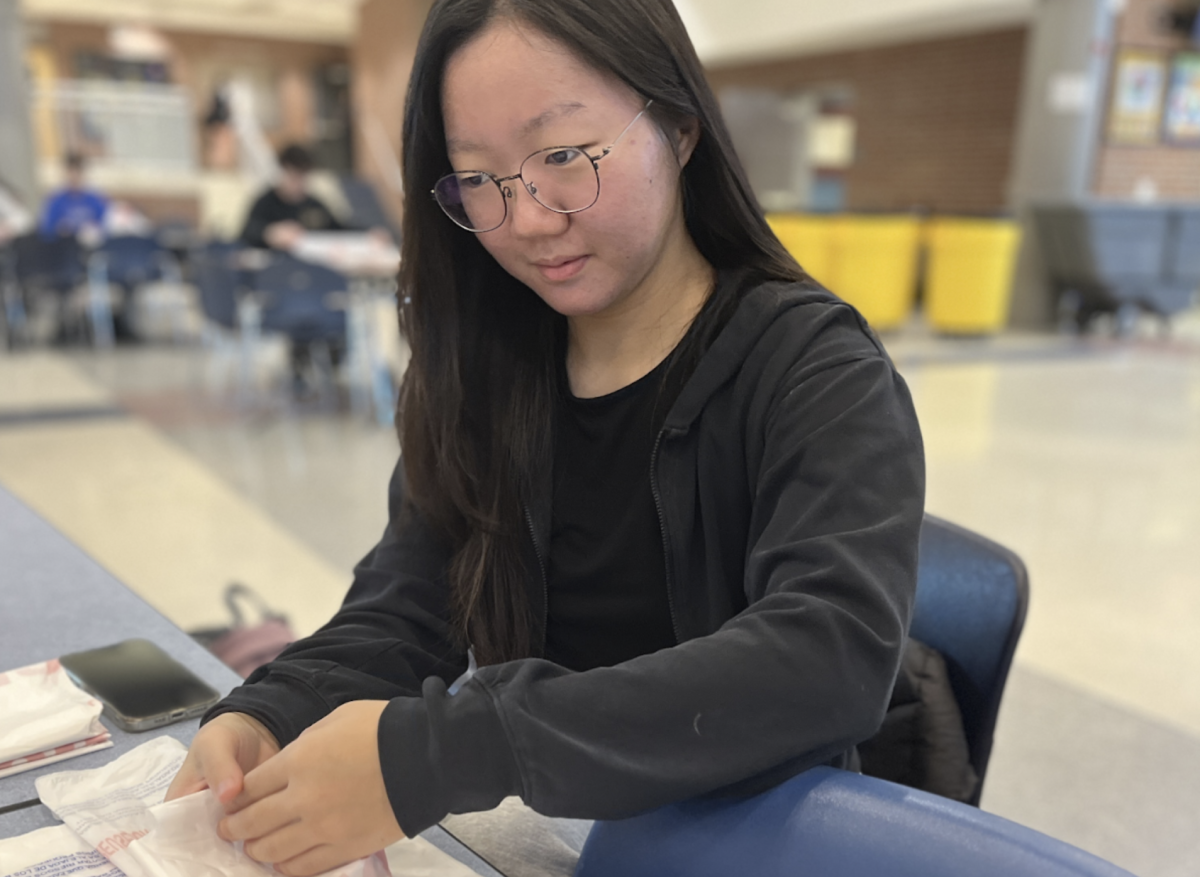 Anna Kim, Key Club member and sophomore, completes volunteer work assembling care packages for senior citizens on March 20. This activity is one example of the club's ongoing service projects before they begin preparations for their spring activities.