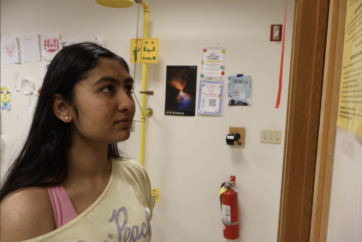 Sophomore Ananya Jain reads the earthquake drill procedures on April 23. Jain was reviewing emergency protocol after reading about the recent disasters in Nev. and Japan. Jain said, “It’s important to take drills seriously because you never know if one might happen. It’s always better to be prepared and not risk your life during an actual emergency.”